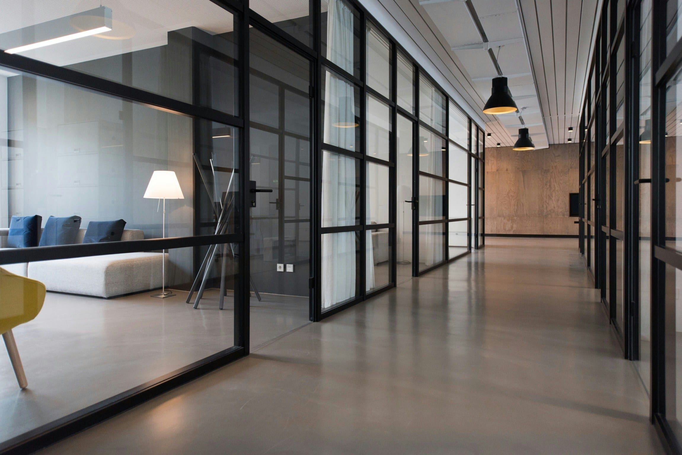 Office corridor lined with glass partition walls and doors